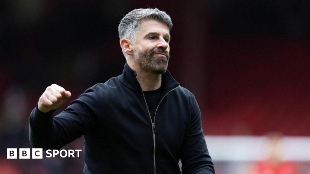 Exciting football match showing action and cheering fans, representing Aberdeen coach Stephen Robinson's impact.