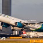 Travelers at an airport discussing Aer Lingus summer flights.