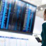 Busy airport terminal showing passengers affected by air travel costs increase.