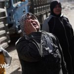 Professionals discussing the arrest of a Tadamon massacre suspect in a serious setting.