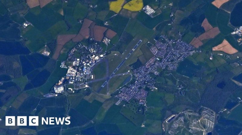 Astronaut taking a photo of a university from space, showcasing the campus layout.