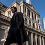 Professionals discussing Bank of England expectations during a meeting.