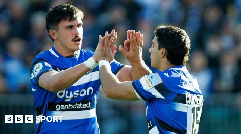 Bath Rugby players celebrating a victory during a match, showcasing teamwork and sportsmanship.