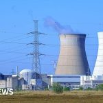 Professionals discussing Belgium nuclear power nationalization in a meeting room.