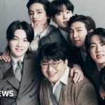 Business professionals discussing legal issues related to BTS creator.