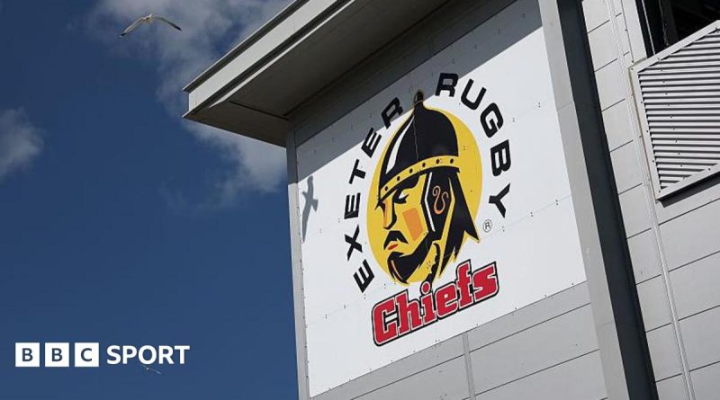 Business professionals discussing the Bournemouth Exeter Chiefs acquisition in a conference setting.