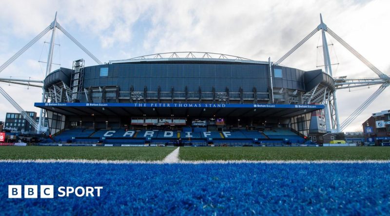 Business professionals discussing Cardiff Rugby takeover negotiations in a modern office.