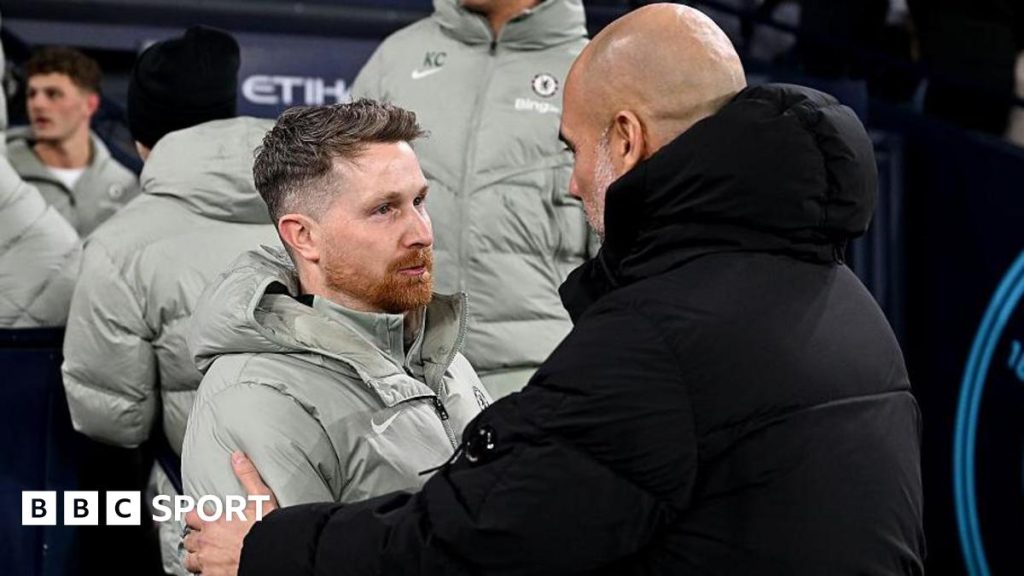 Chelsea interim coach leading football training with team players.