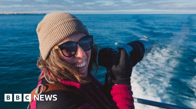 Choir members singing with whale sounds in a coastal setting.