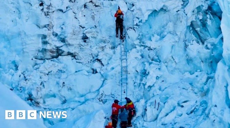 Climbers on a snowy Everest path face ongoing risks of ice hazards.