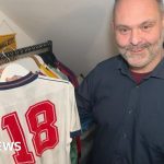 Professionals discussing the value of England football shirts at a market