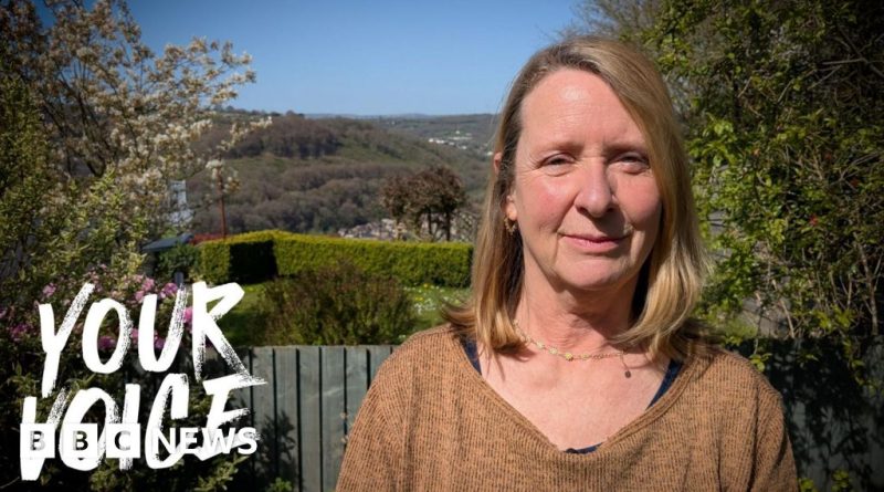 Professionals discussing wind farms in Wales amidst green hills.