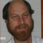 A group of scientists engaged in a serious discussion about research related to missing scientists.