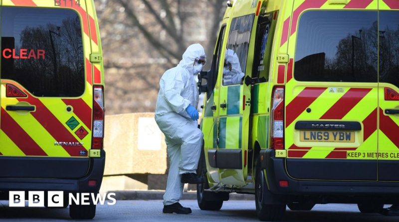 NHS healthcare workers providing care in a busy hospital environment, reflecting NHS Covid guidelines.