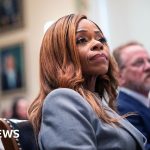 A diverse group discusses campaign finance scandal in a formal meeting.