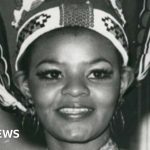 Cynthia Shange Miss World contestant in elegant conservative attire at event.