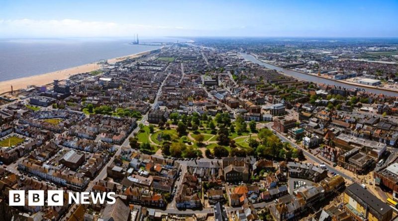 A meeting discussing debt struggles in a coastal town, with professionals in business attire.