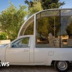 A professional team discussing the Popemobile for Gaza children's clinic.