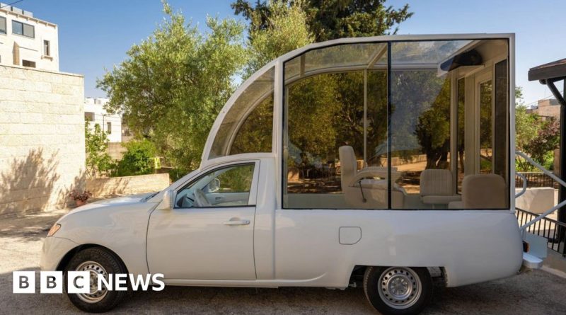 A professional team discussing the Popemobile for Gaza children's clinic.