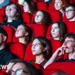 Audience in a theater enjoying a film without disruptions.