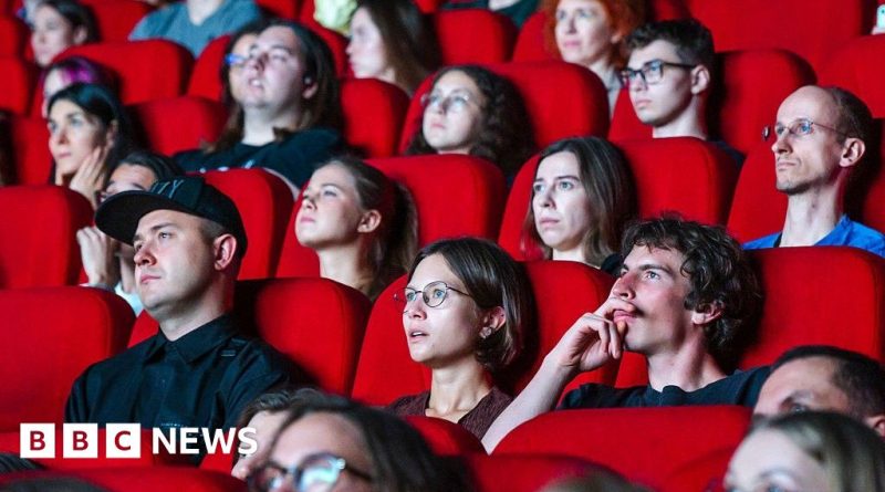 Audience in a theater enjoying a film without disruptions.