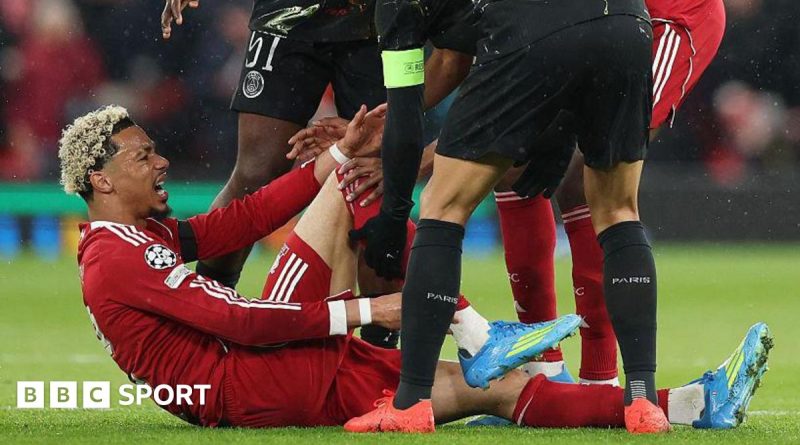 A football coach watches a match, worried about Ekitike injury news.