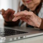 Elderly woman examining car insurance paperwork, highlighting the car insurance mistake.