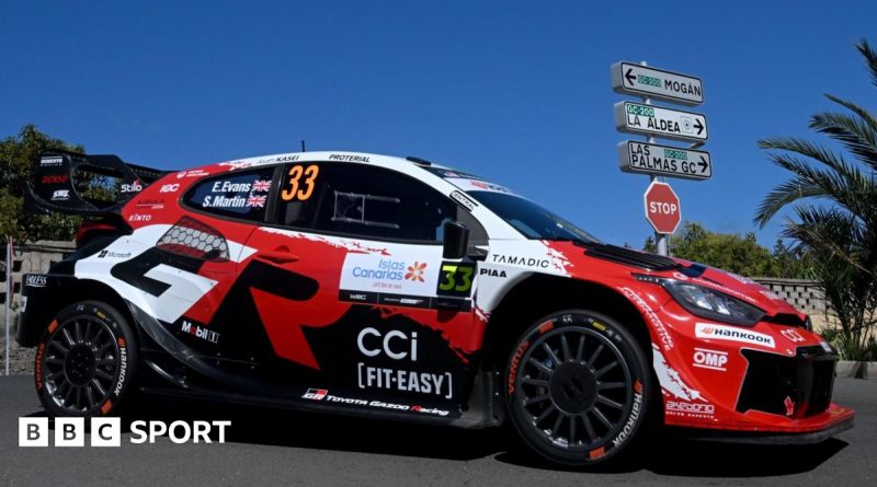 Rally drivers strategizing in the paddock during the World Rally Championship.
