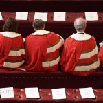 Professionals discuss House of Lords changes in a parliamentary setting.