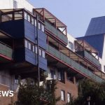 Diverse professionals discussing Byker Wall energy bills in an office.