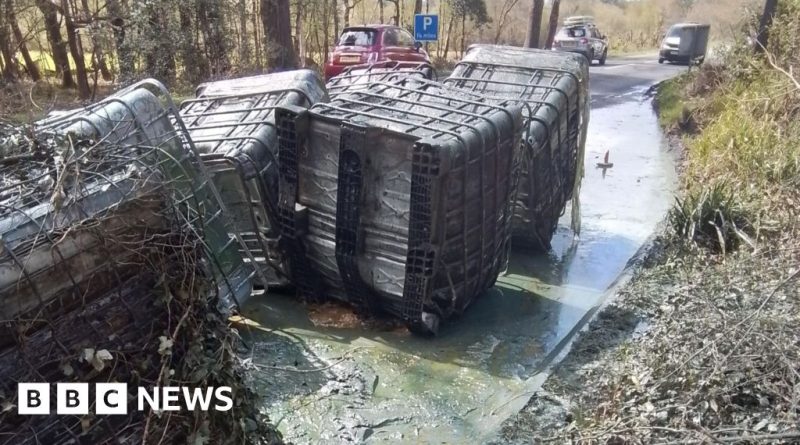 Environmental workers assess liquid waste containers by the roadside.