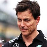 A focused business meeting discussing F1 rules changes with charts.