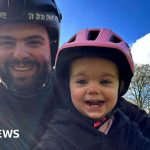 A father and daughter share a joyful bike ride, showcasing their bond.