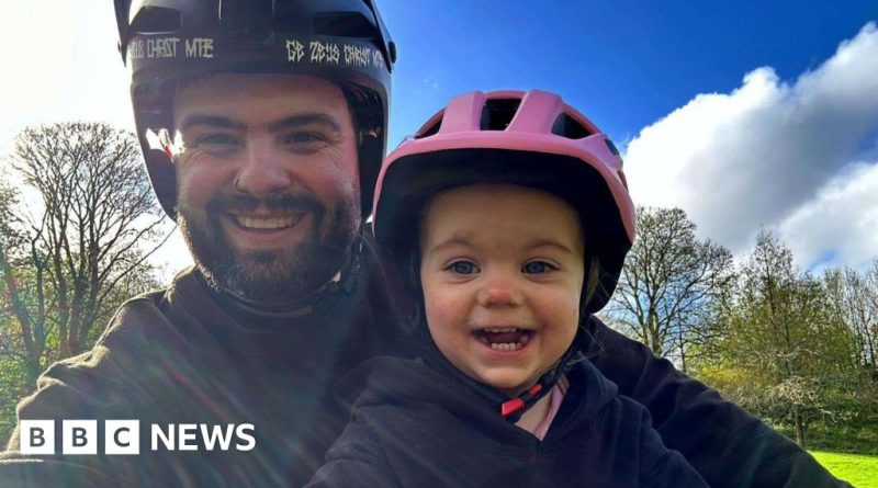 A father and daughter share a joyful bike ride, showcasing their bond.
