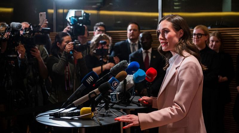 A group of professionals discussing Finland election results in formal attire.