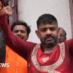 Politicians holding fish at a West Bengal political rally, expressing cultural pride.