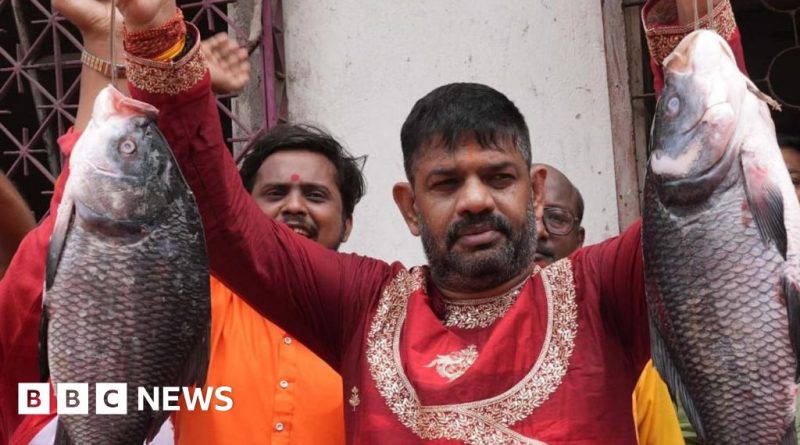 Politicians holding fish at a West Bengal political rally, expressing cultural pride.