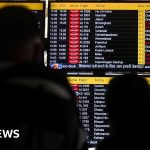 Business professionals discussing flight delays and cancellations at the airport terminal.