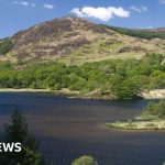 A professional group discussing the Galloway National Park project in a scenic outdoor setting.
