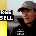 George Russell discussing competition with fellow drivers at a Formula 1 event.