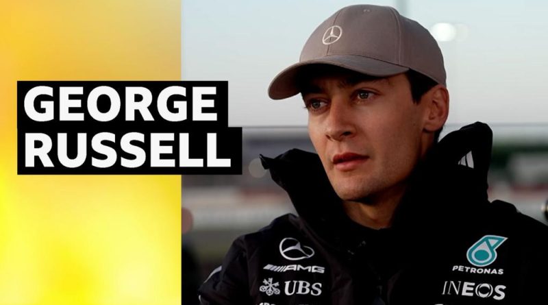 George Russell discussing competition with fellow drivers at a Formula 1 event.