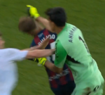 A tense scene of goalkeeper assault during a soccer game in Spain.