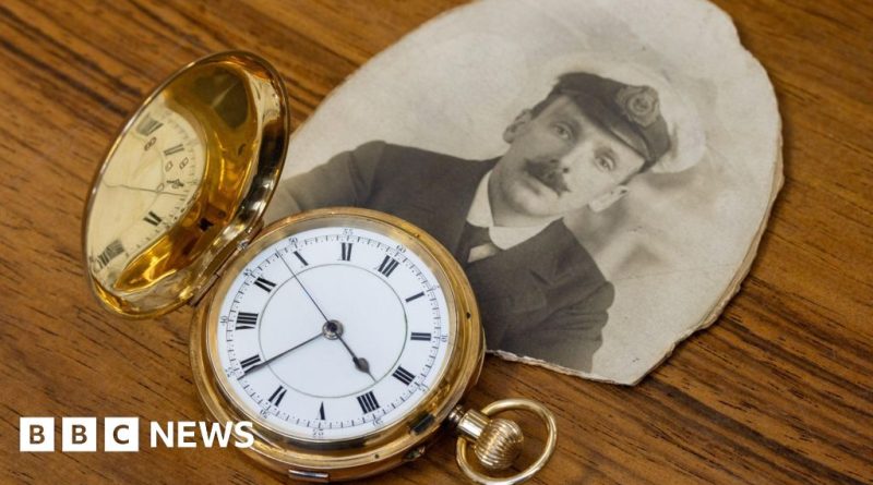 Titanic rescuer gold watch displayed with historical maritime items.