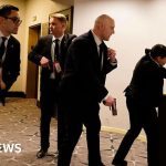 People in a hotel ballroom reacting to the Washington hotel gunfire incident.