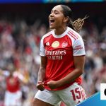 A women's soccer match showing players in action after a Lyon goalkeeping error.