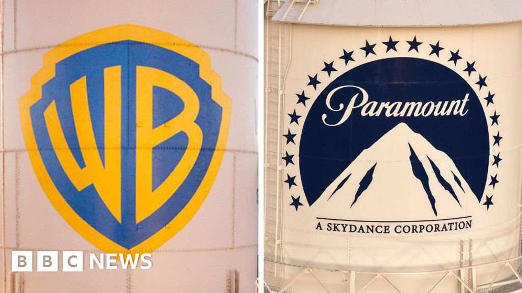 Professionals discussing the Paramount Warner Bros acquisition in a meeting.