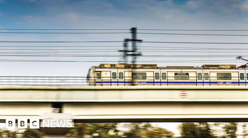 Commuters in professional attire waiting at an India metro station.
