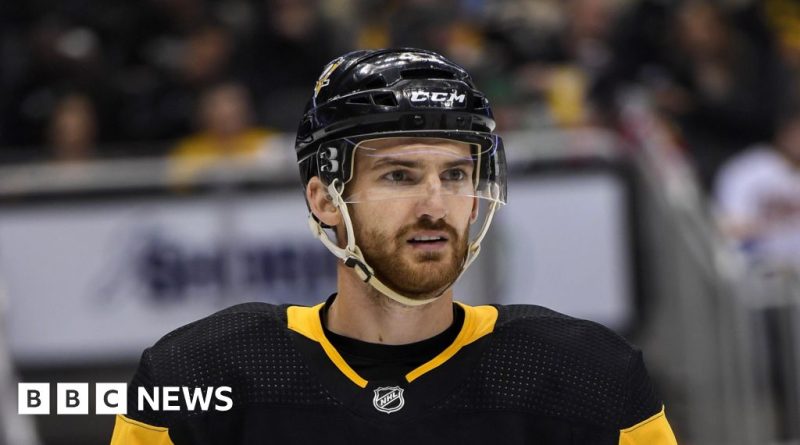 Emergency medical personnel attending to Adam Johnson during a hockey game.