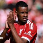 Excited football fans celebrating Isak's first goal for Liverpool at Anfield.