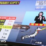 Professionals discussing Japan earthquake alert and safety plans in a meeting.